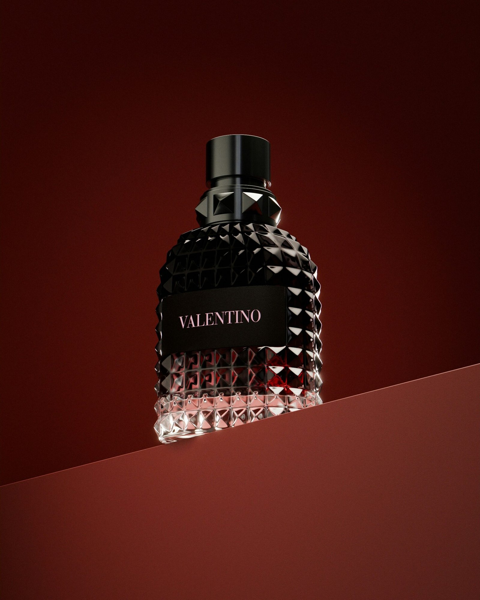 a bottle of perfume sitting on top of a red surface