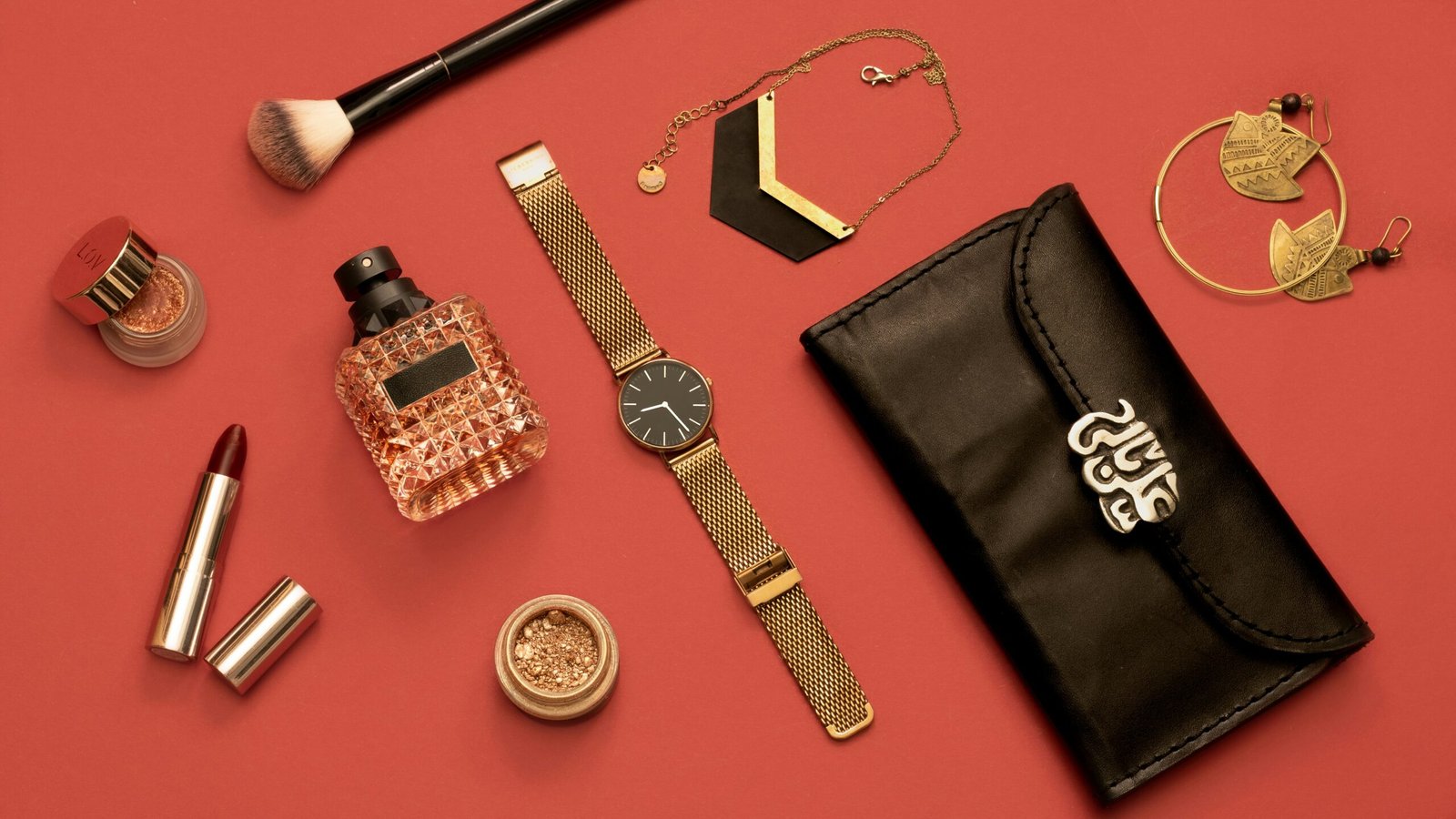 an assortment of women's accessories on a red surface